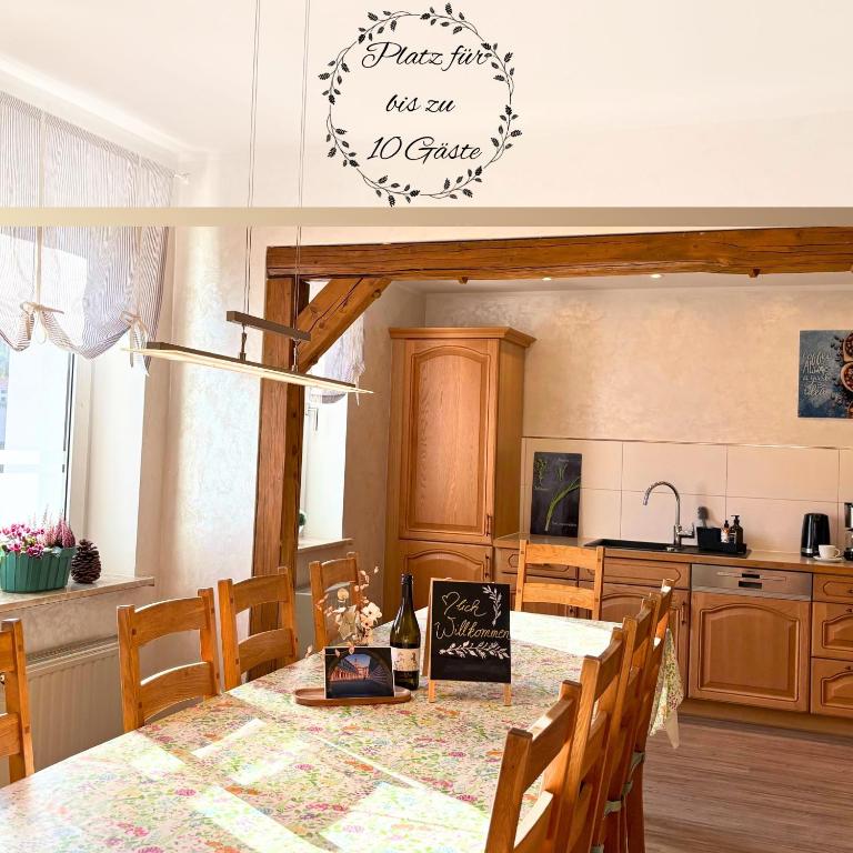 a kitchen with a dining table with a sign on the wall at Ferienhaus Landeskrone für 10 Personen mit Sauna, Terrasse, inkl Parkplatz in Dresden in Dresden