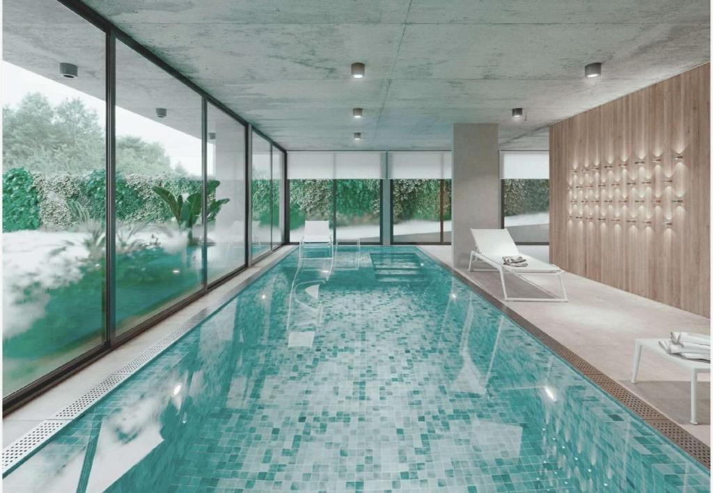 a swimming pool in a building with glass windows at Sea Side2 in Piriápolis