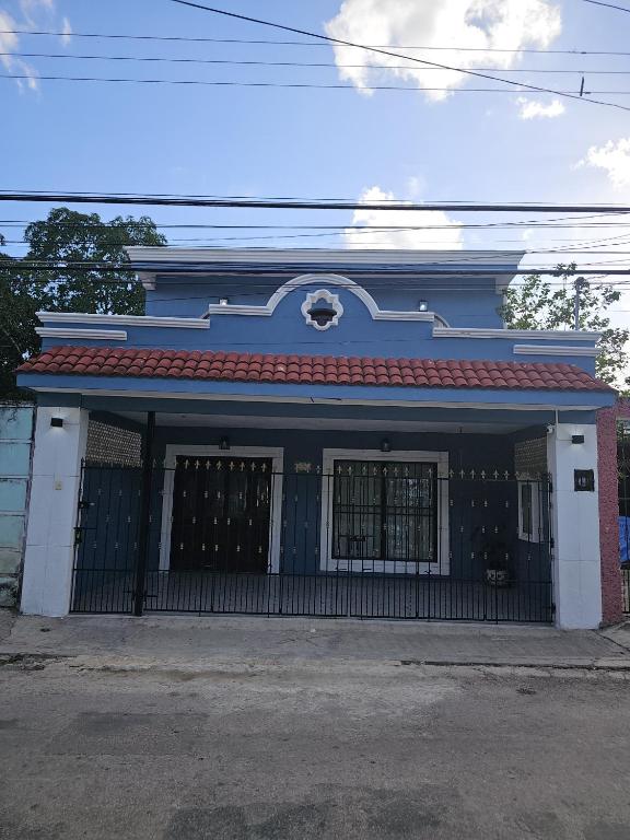a blue and white building with a gate at Casa X-lapac in Valladolid