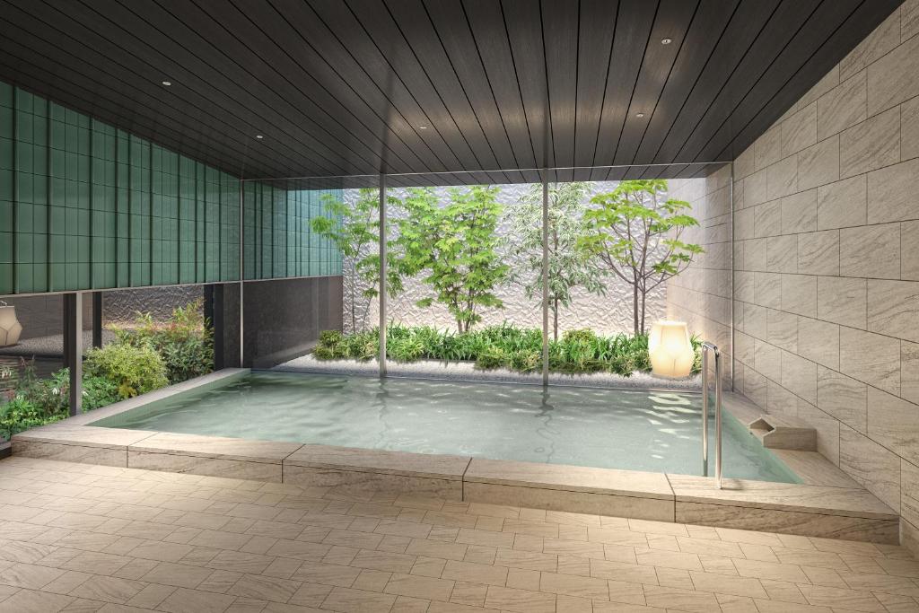 a jacuzzi tub in a building with a large window at Mitsui Garden Hotel Okayama in Okayama