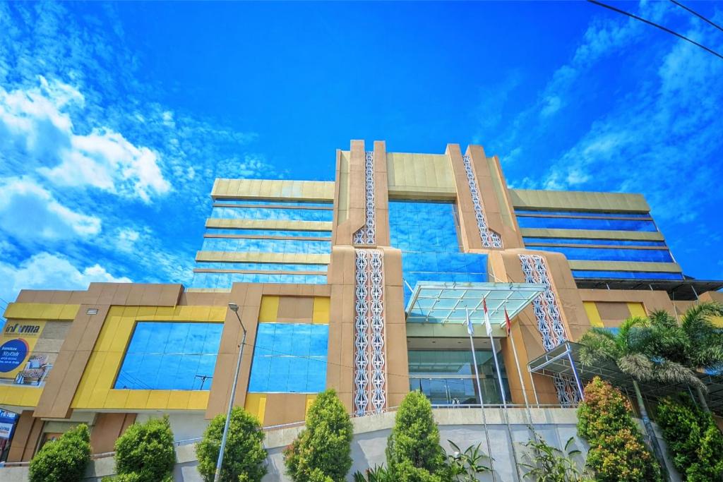 a tall building with a blue sky in the background at Manna Hotel Pematangsiantar in Pematangsiantar