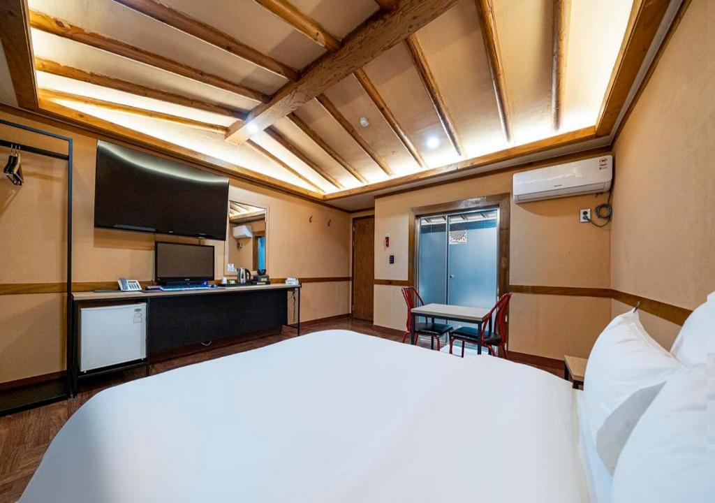 a hotel room with a bed and a flat screen tv at Hotel Petit Gimpo in Gimpo