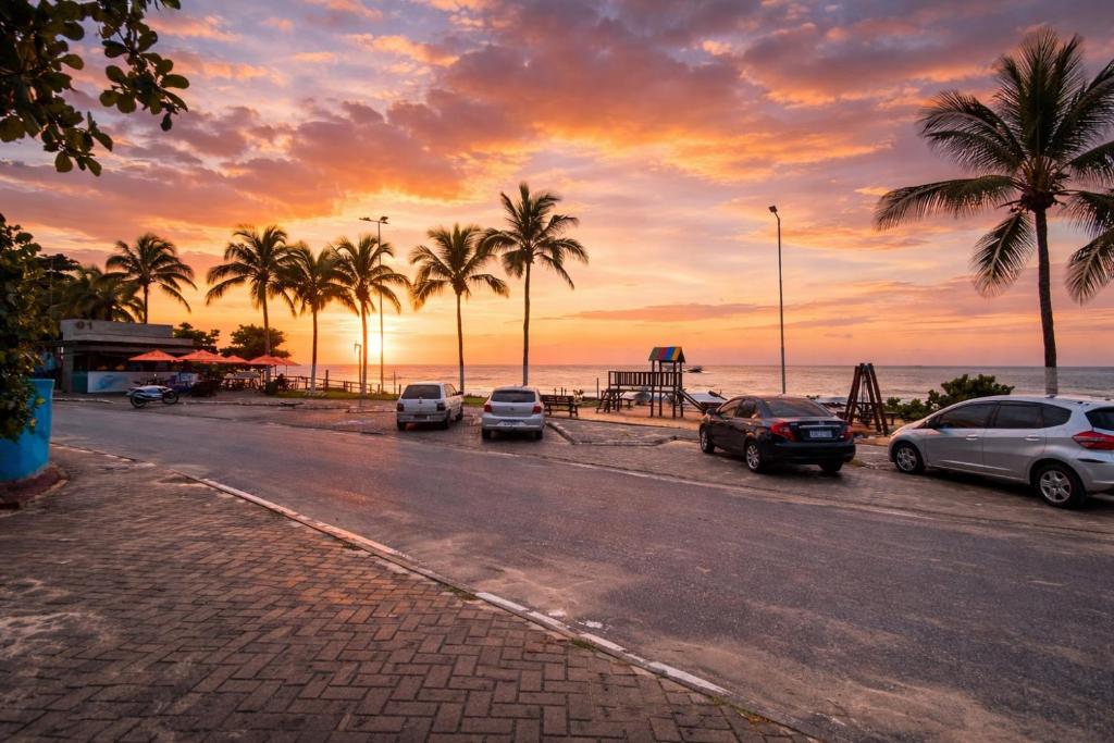 a group of cars parked on a street with palm trees at Meu Point Itauna 1 - Paraíso a 50 Metros do Mar in Saquarema