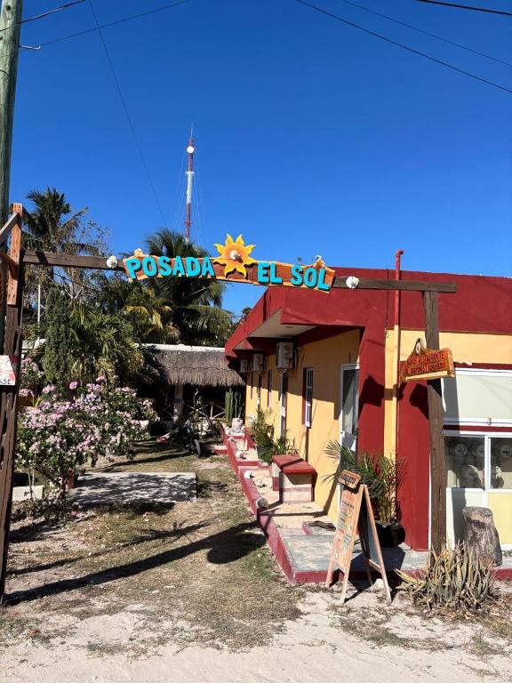 a red and yellow building with a sign on it at Posada el Sol in El Cuyo