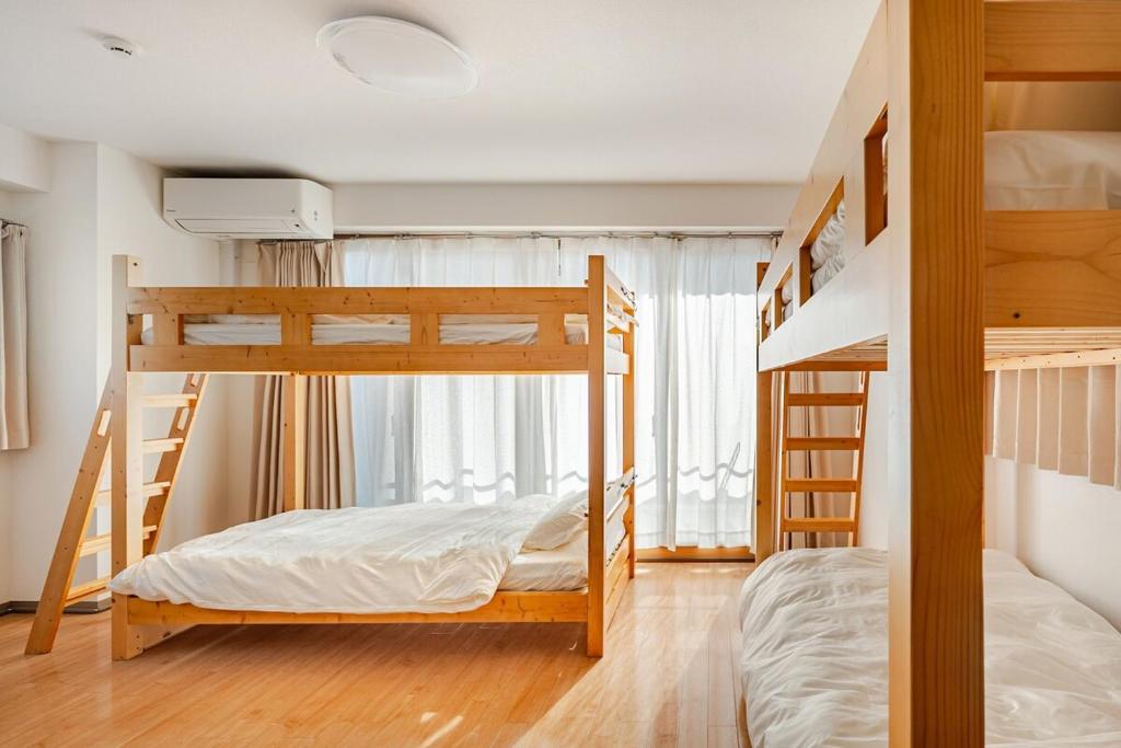 a bedroom with two bunk beds and a window at ライズ 2人部屋 か4人部屋 in Kasugai