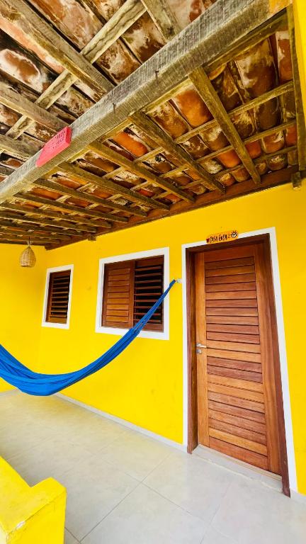 a yellow wall with a door and a garage at Casas Gica in Pipa