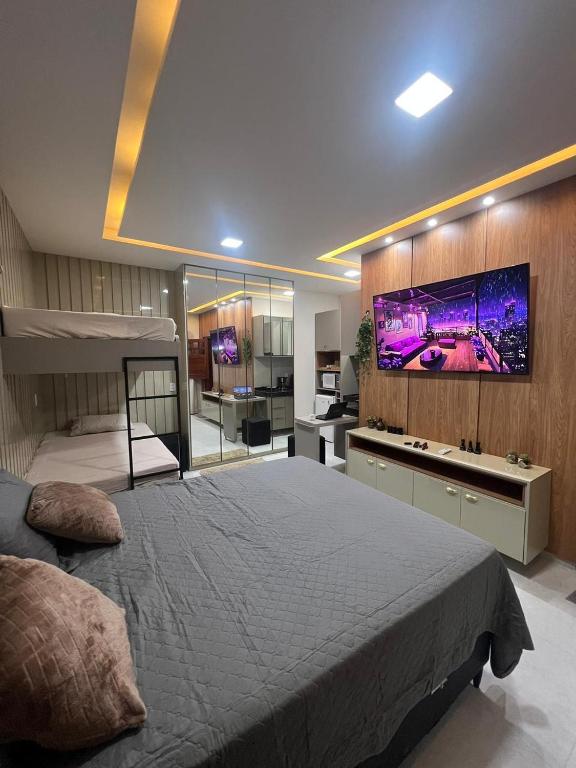 a bedroom with a large bed with a tv on the wall at Residencial Ibiapaba - APARTAMENTO COMPLETO in Camocim