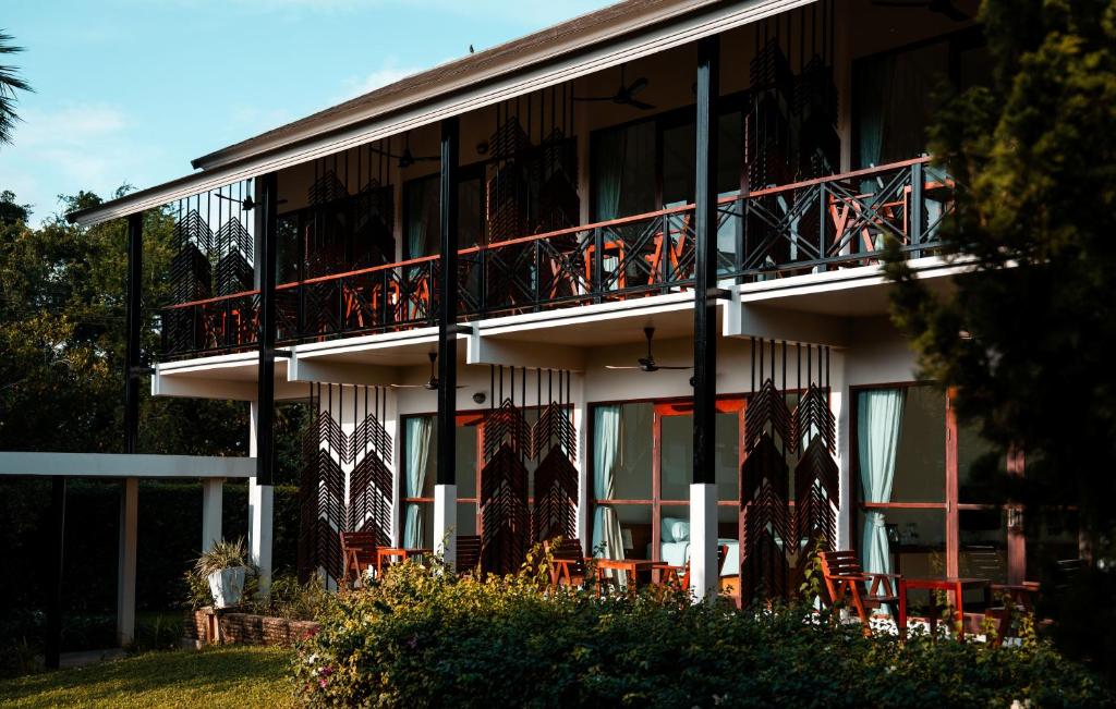 a building with a balcony with tables and chairs at Ma Villa Khao Yai in Mu Si