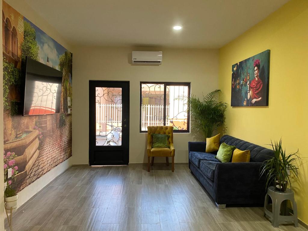 a living room with a black couch and yellow walls at Penthouse Casa Polican in Tuxpan