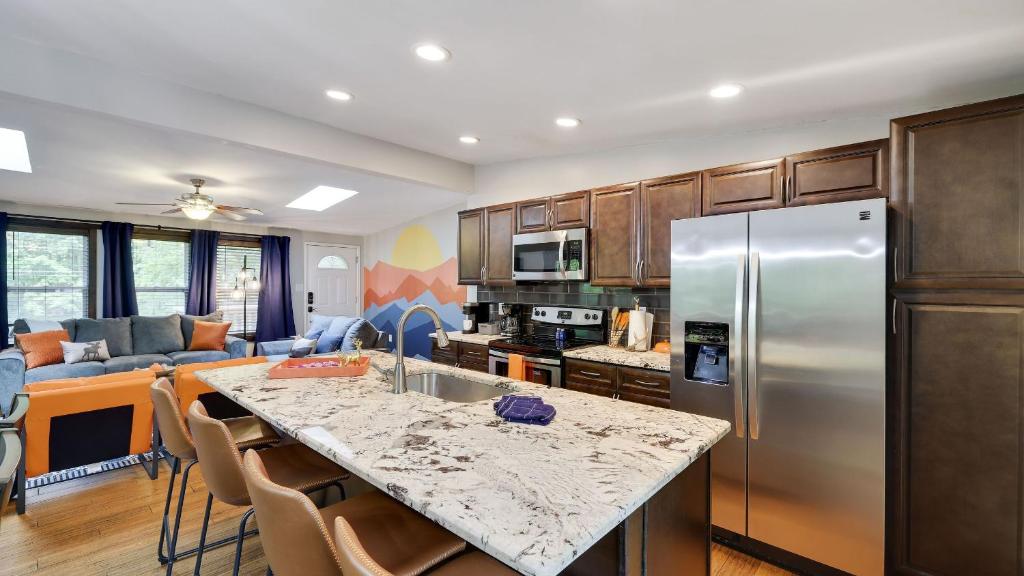 a kitchen with a stainless steel refrigerator and a living room at Moshannon by AvantStay in Pocono Lake