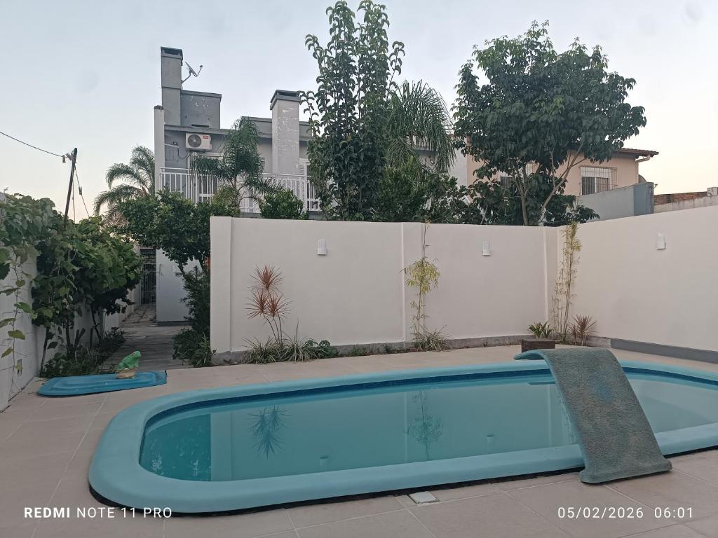 a swimming pool in front of a white fence at Casa Belíssima in Pelotas