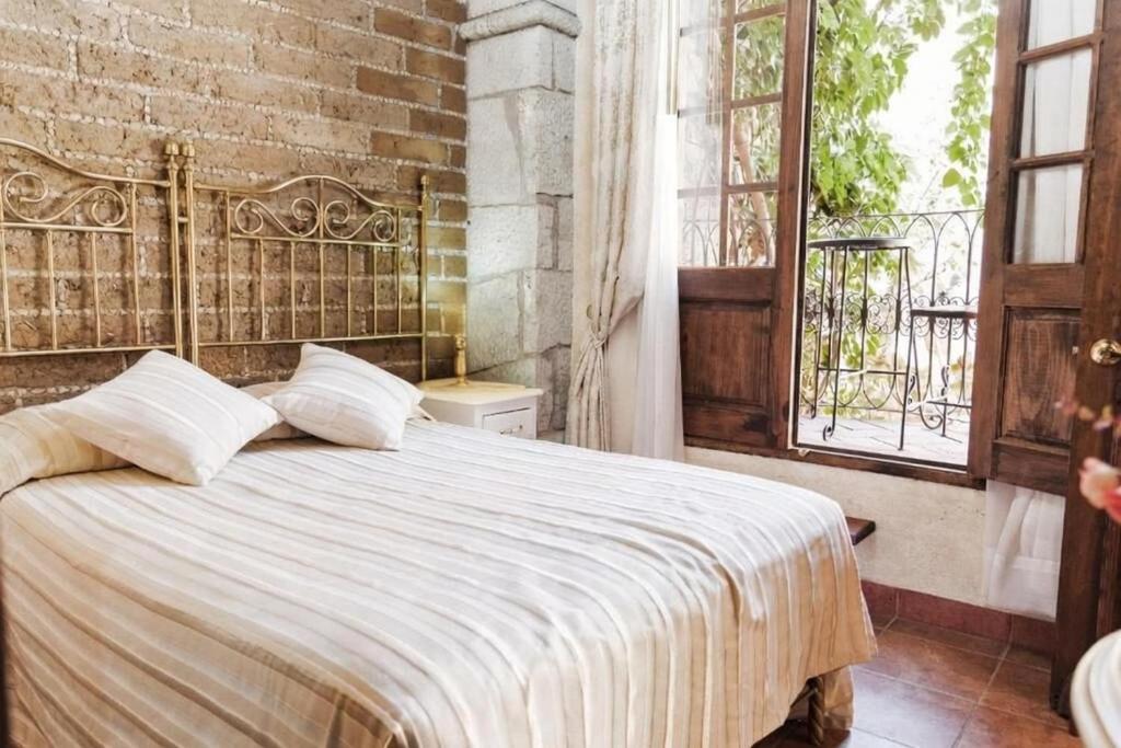 una camera da letto con un grande letto e un muro di mattoni di Hotel Na-anché Aeropuerto a Città di Oaxaca