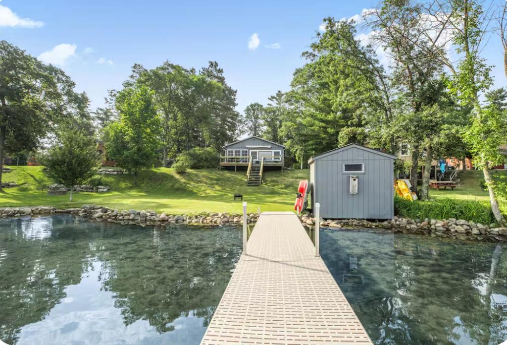 a tiny house on a dock next to a body of water at The Cozy Cub in Cross Lake