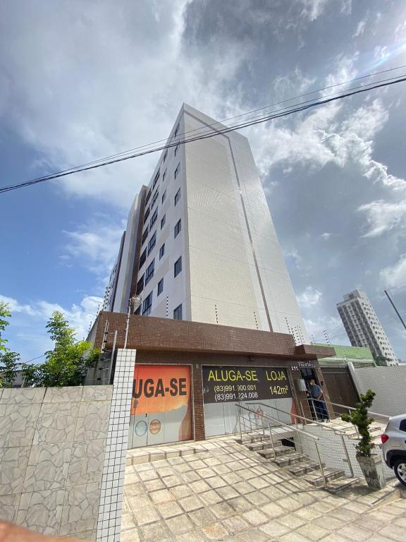 a tall white building in front of a building at Flat Apartamento Mobiliado na Prata in Campina Grande