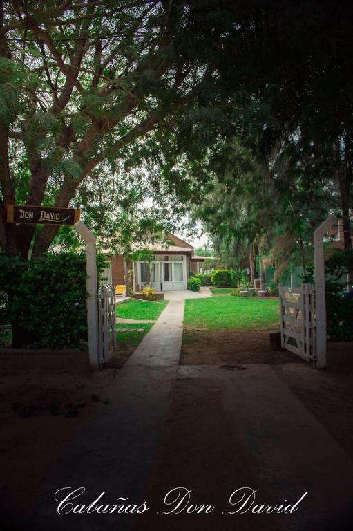 a driveway leading to a yard with a gate and a house at Cabañas Don David in Paso de la Patria