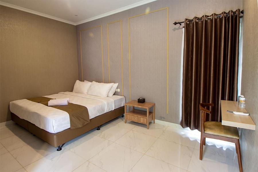 a bedroom with a bed and a desk and a window at Wakayapa Syariah Residence in Dahung