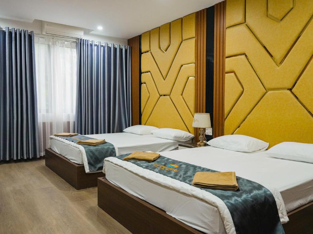 a hotel room with two beds and a window at Ruby 25 Hotel in Hà Ðông