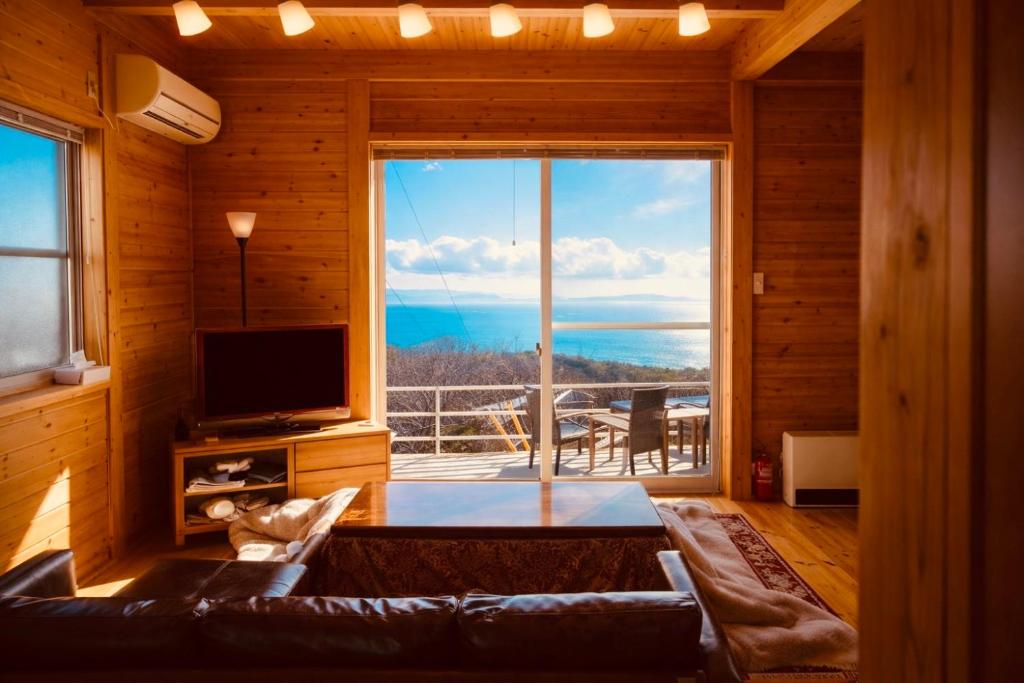 a living room with a couch and a large window at #25 牛窓 lodge in Setouchi