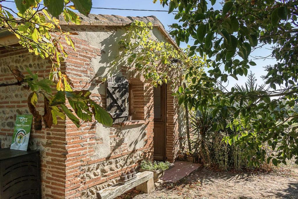 an old brick house with a window and a door at Le cabanon in Mauressac