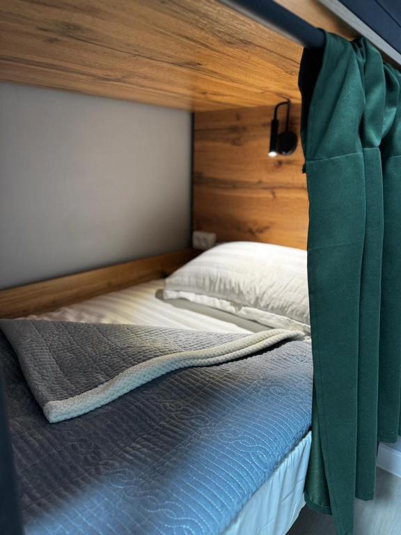 a bedroom with a bed with a green curtain at HOSTEL Q7 Almaty in Almaty