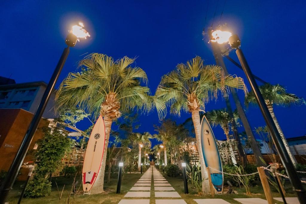 a row of palm trees with surfboards on them at Glamping Trailer Lanikai in Awaji