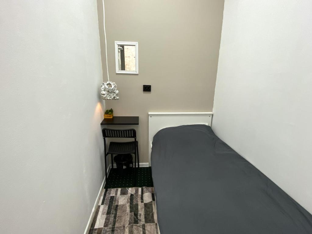 a small room with a bed and a chair at Pulse capsule hotel in Almaty