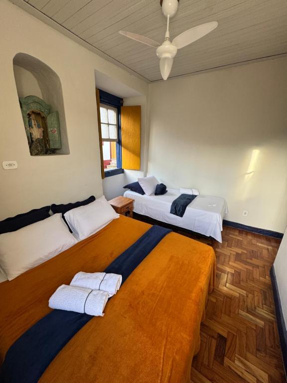 a bedroom with two beds and a ceiling at Pouso History in Ouro Preto