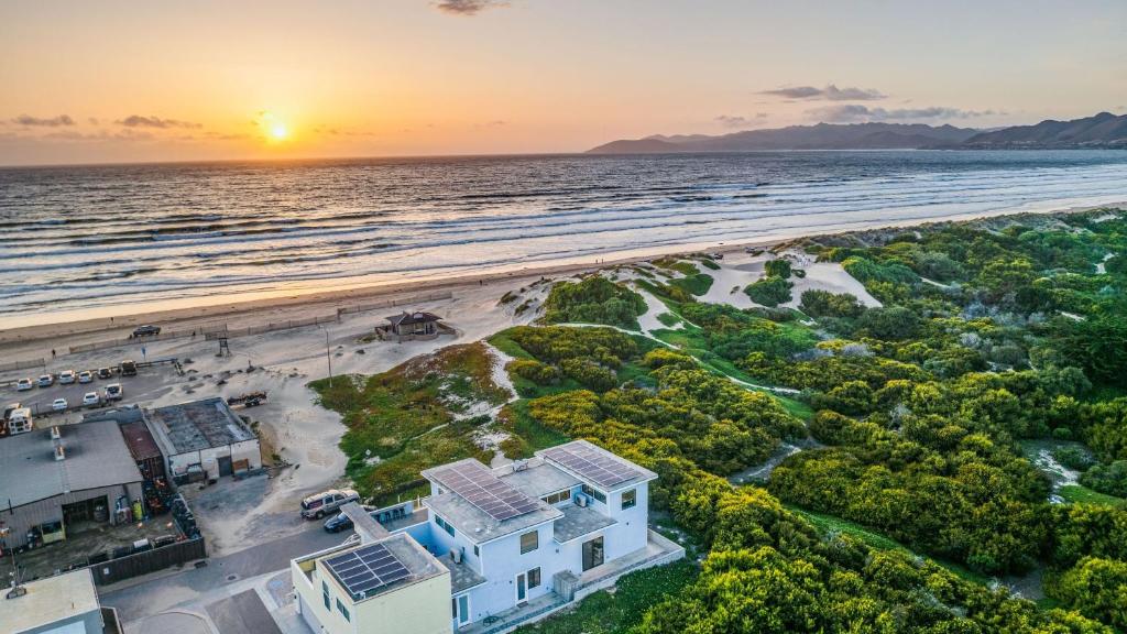 an aerial view of a house on the beach at sunset at Strand Way A B by AvantStay in Oceano