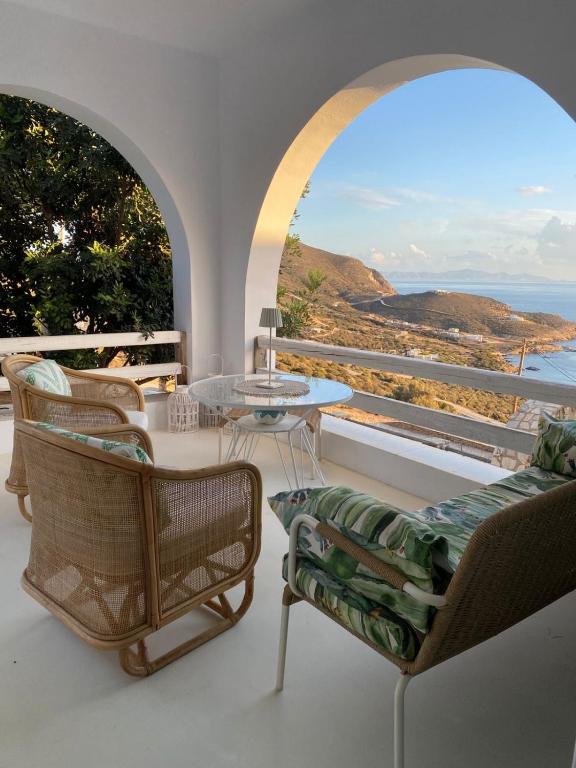 a balcony with a table and chairs and a view of the ocean at Lobster House Antiparos in Antiparos