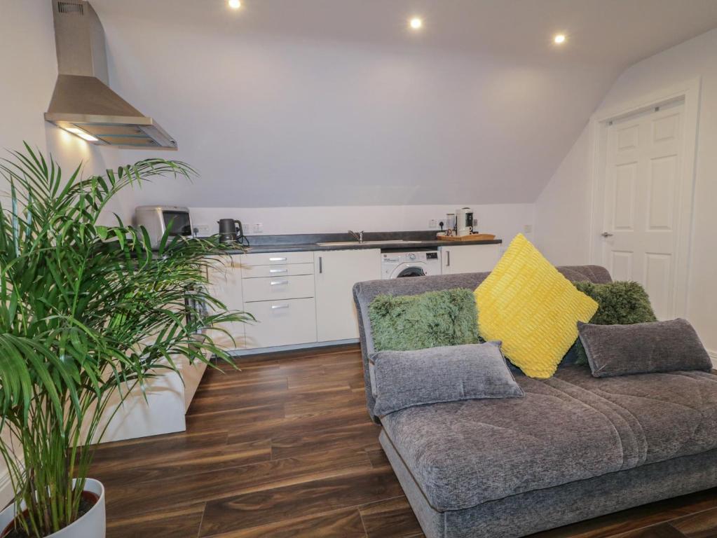 a living room with a couch and a kitchen at The Loft - 96B in Articlave