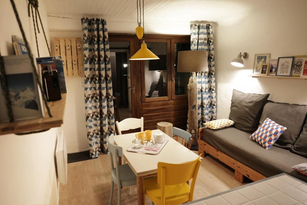 a living room with a table and a couch at Jour De Peuf in Champagny-en-Vanoise