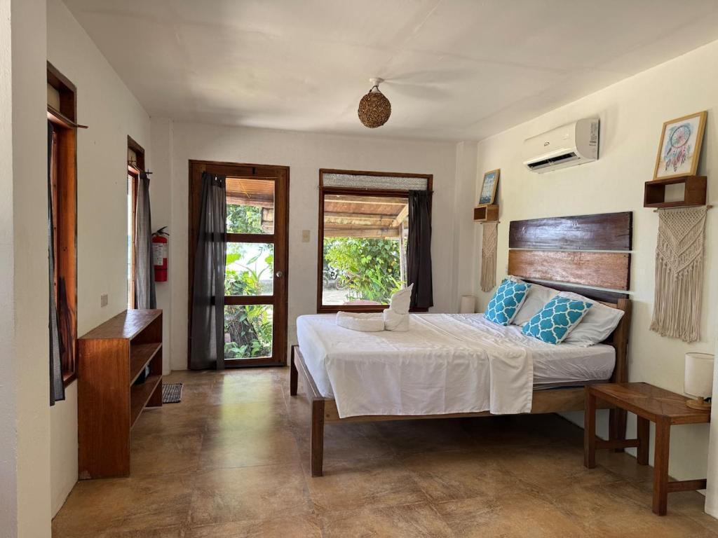 a bedroom with a bed with blue pillows on it at Malinao Beachfront Studio, Starlink, Solar in General Luna