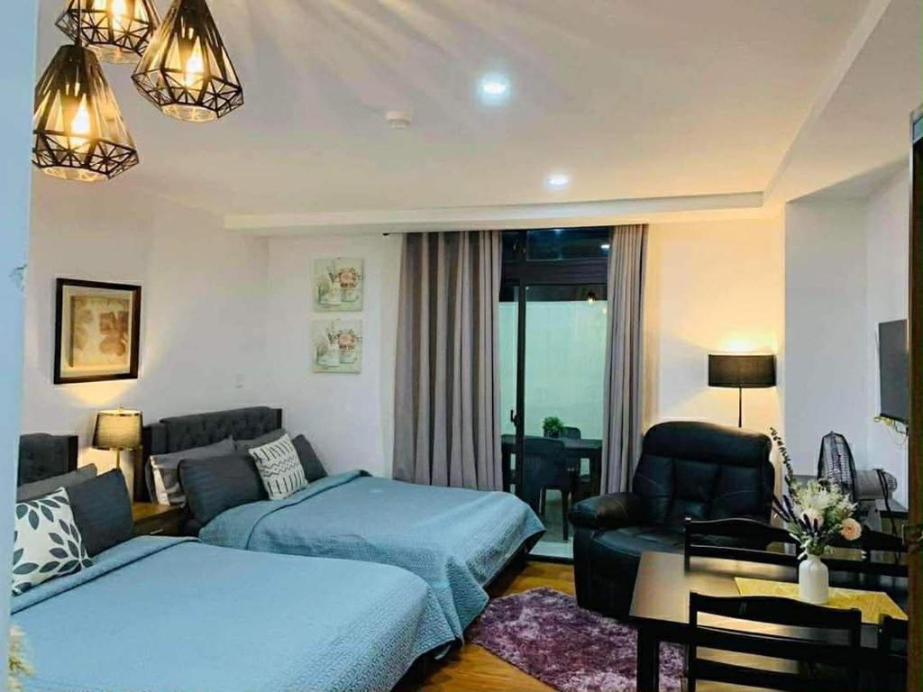 a bedroom with two beds and a living room at EA Staycation in Baguio