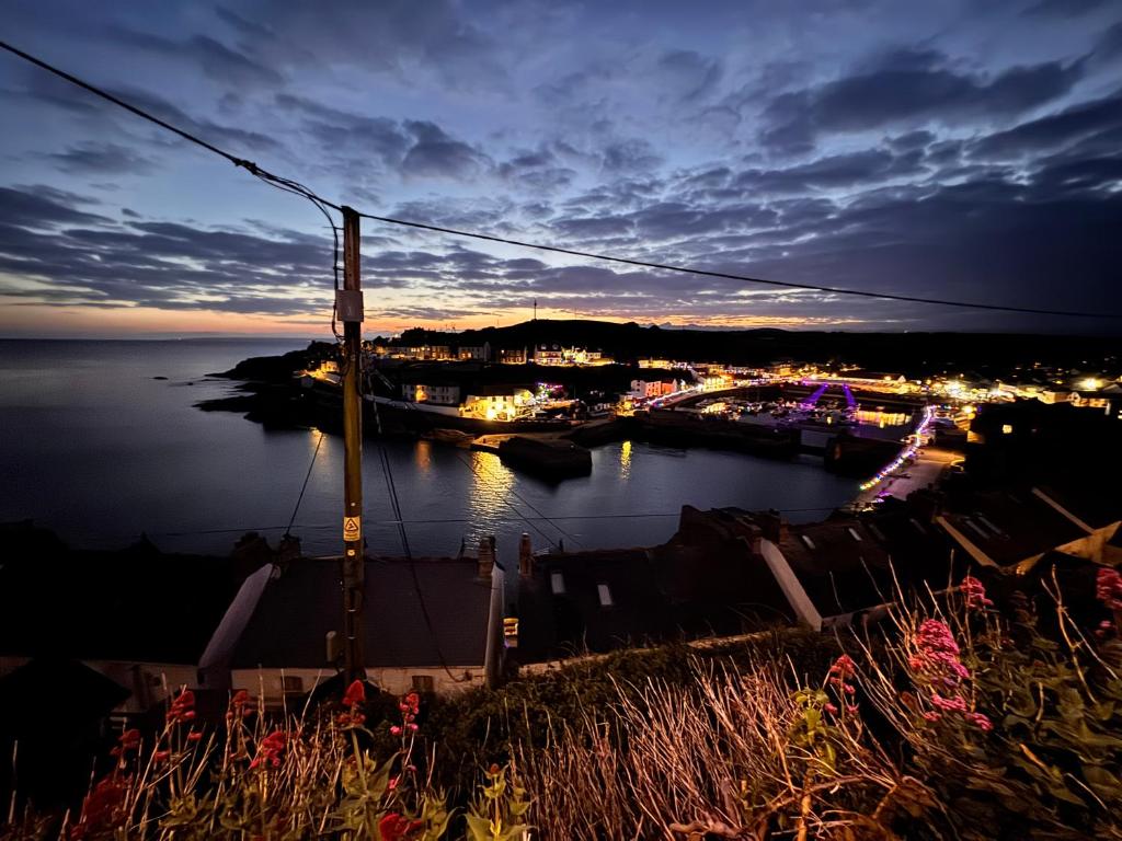 a view of a body of water at night at Harbour Hideaway, Porthleven in Porthleven