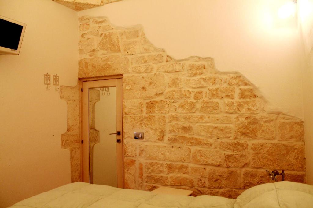 a bedroom with a stone wall with a bed in it at Dream Home in Ostuni