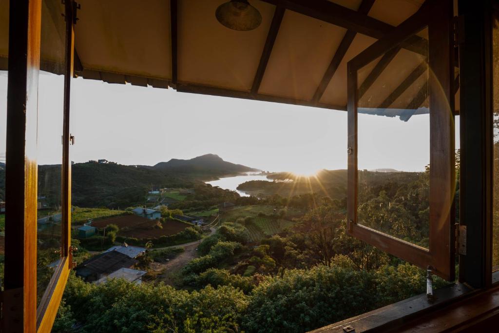 a view of the ocean from a window at Amansara Bungalow - Panoramic Lake View Villa, Nuwara Eliya in Nuwara Eliya