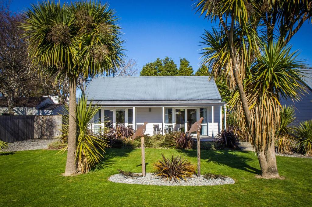 een huis met palmbomen ervoor bij Greyfriars Motel in Greytown