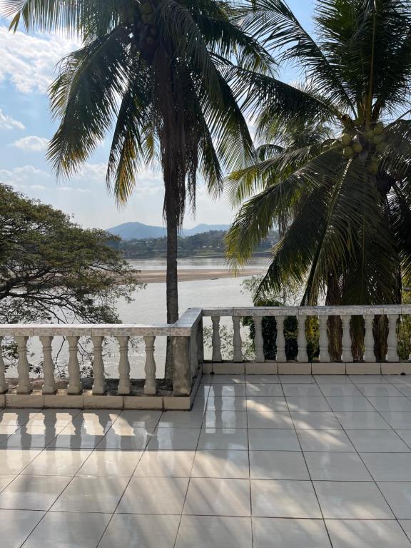 a white fence and a view of the water at Khopchai Guesthouse in Ban Houayxay