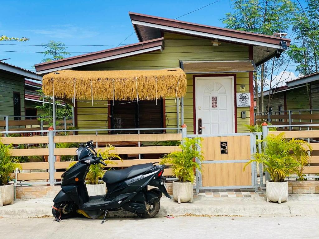 a scooter parked in front of a house at Olango Island - S&E-1 Tiny Guest House Fully Furnished with Hot Shower, Washer, Wi-Fi, Netflix & King-size Bed in Lapu Lapu City