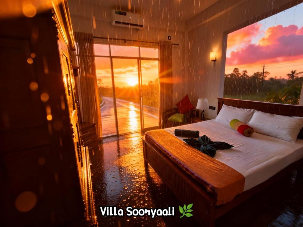a bedroom with a bed with a view of a sunset at Villa SOORYAALI in Galle