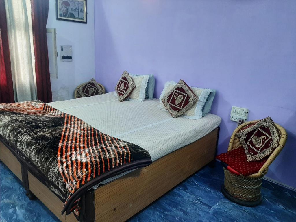 a bed with pillows on it in a room at Hotel Ashu , Ntl Road in Haldwāni