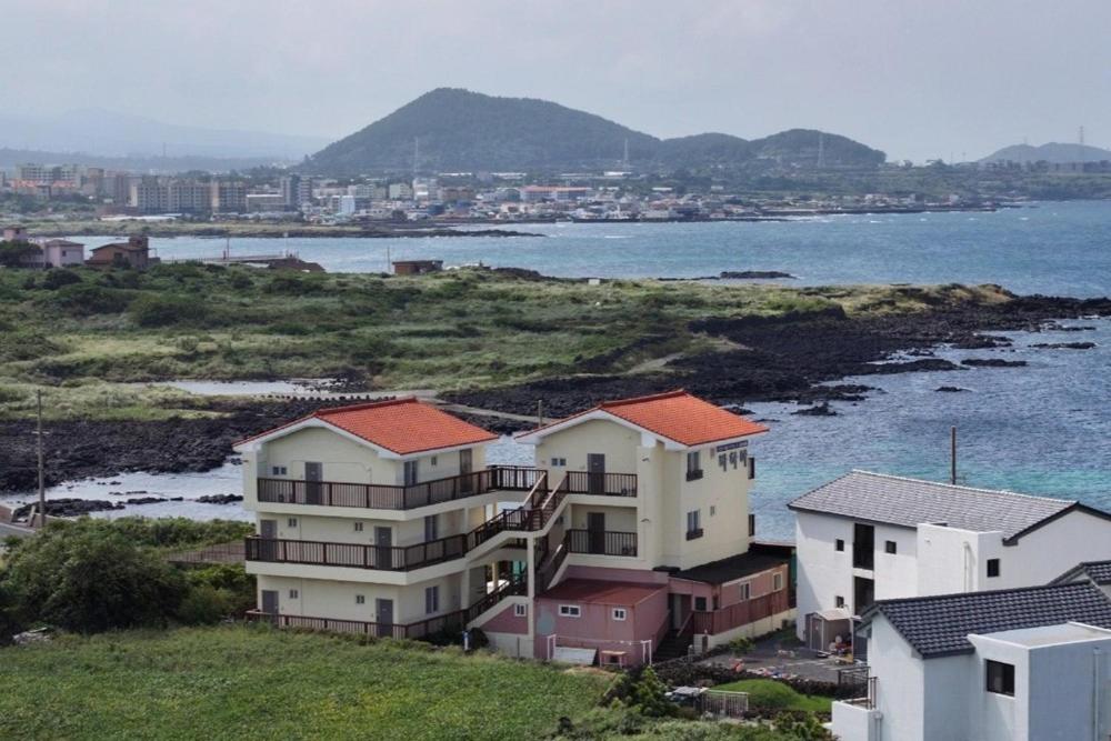 a group of houses on a hill next to the water at Jeju Bahama Pension in Jeju