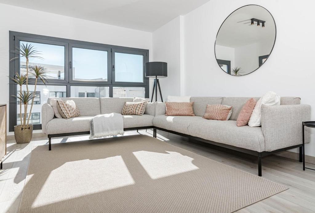 a living room with a couch and a mirror at EG5.4A - Luxury Penthouse with Private Sun Terrace in Estepona