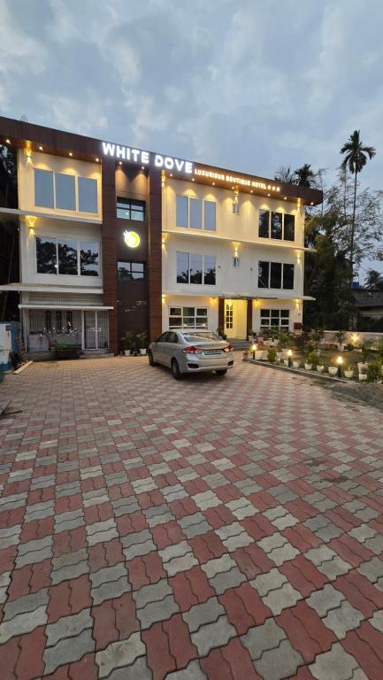a building with a car parked in front of it at White Dove Luxurious Boutique Hotel, within 3 Km from Guwahati Airport in Guwahati