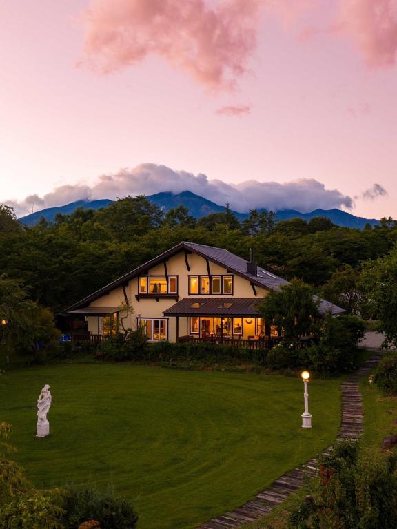 a house on a hill with mountains in the background at ReTune Hokuto in Hokuto