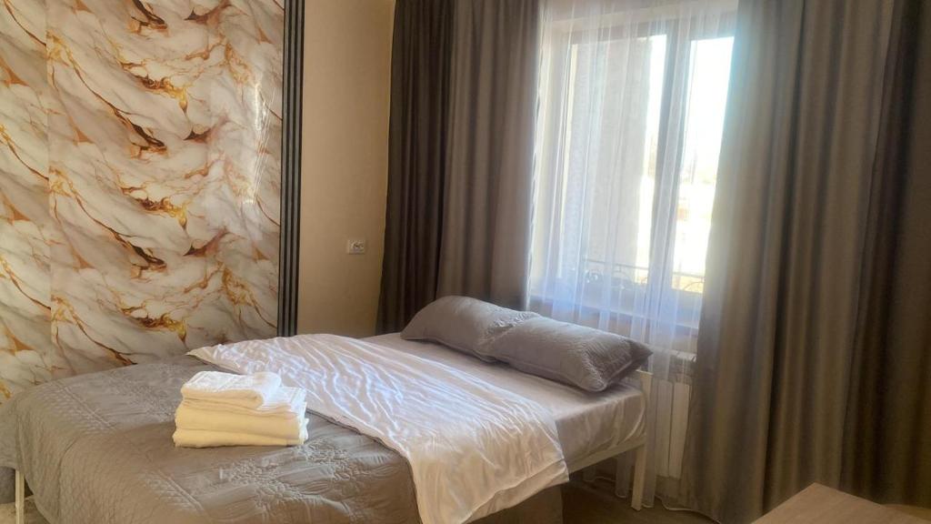 a bedroom with a mirror and a bed and a window at Green apple in Almaty
