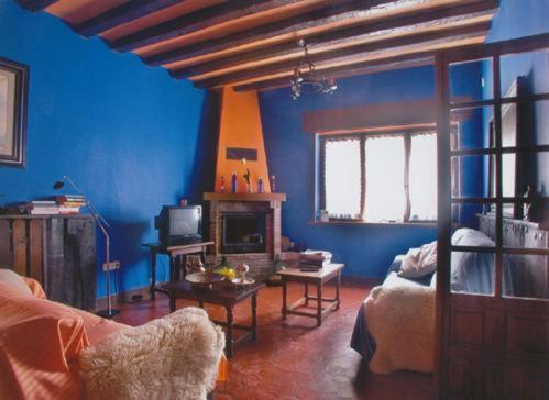 Hotel Ibaiondo في أولاف: غرفة معيشة زرقاء مع أريكة ومدفأة