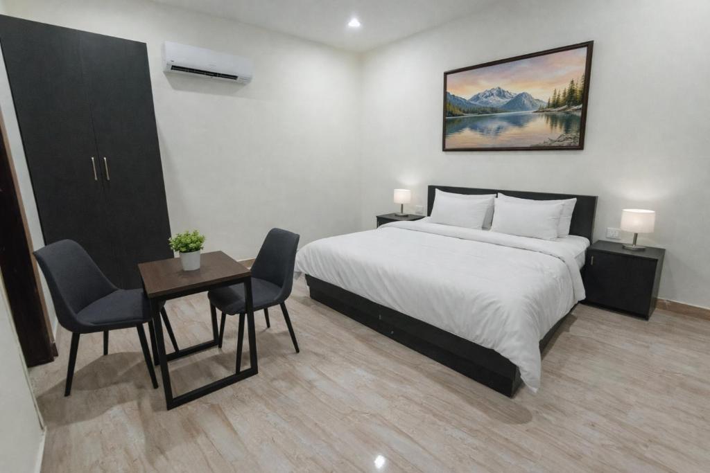 a bedroom with a bed and a table and chairs at BODHI Residency in Greater Noida