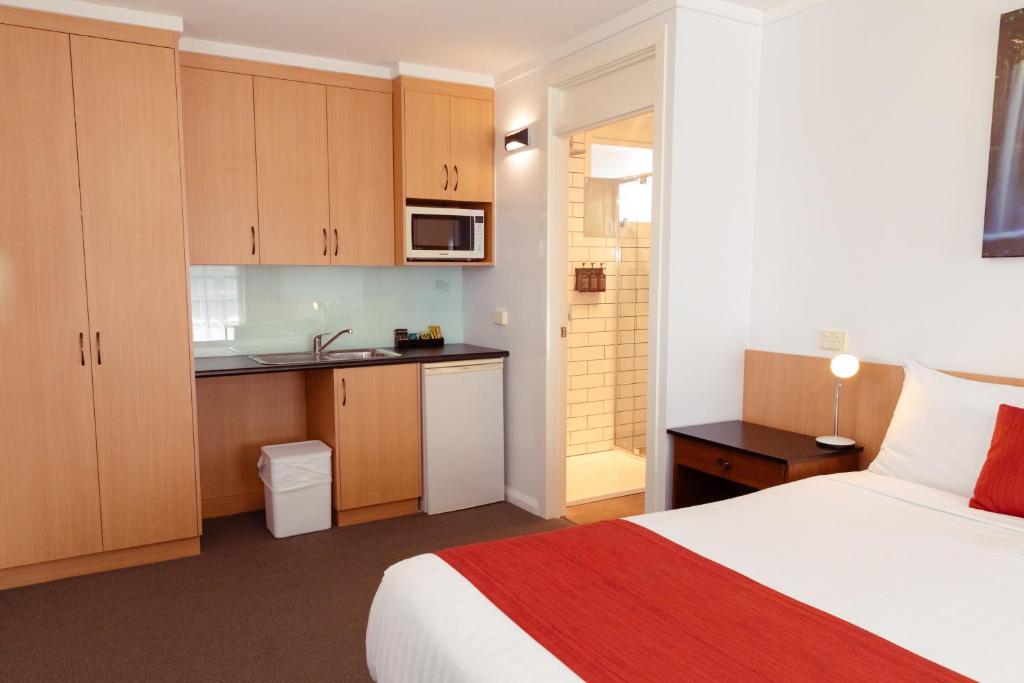 a hotel room with a bed and a kitchen at Barclay Motor Inn in Devonport