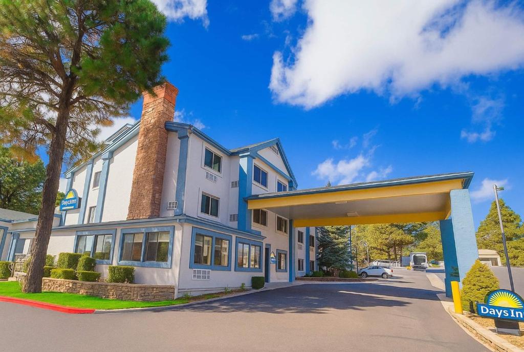 a large white building with a chimney at Days Inn & Suites by Wyndham East Flagstaff in Flagstaff